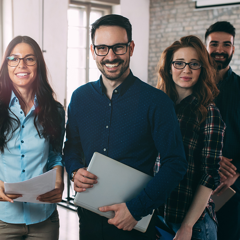 A team of colleagues smiling in the office