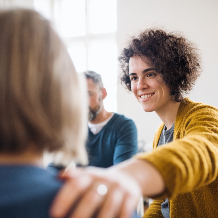 Men and women sitting in circle supporting each other