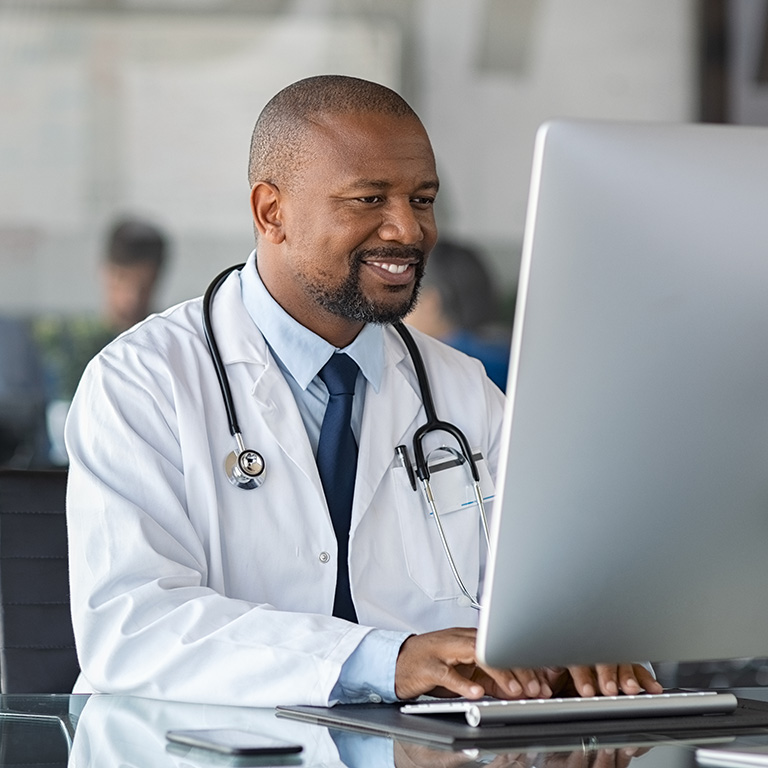 African mature doctor working on computer