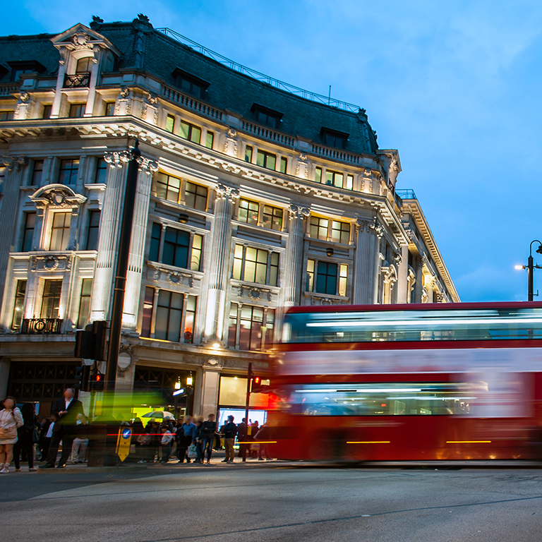 People and double decker red bus cross Oxford Circus, the busy intersection of Oxford Street and Regent Street in the West End of London 