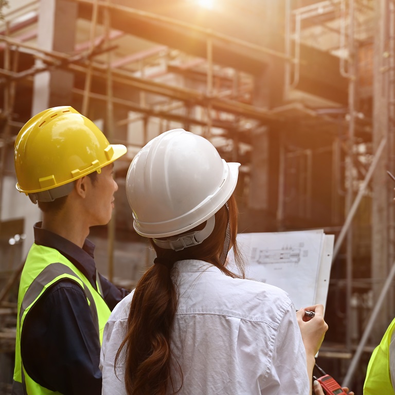 Rear view of the Group of contractors supervising the building process.