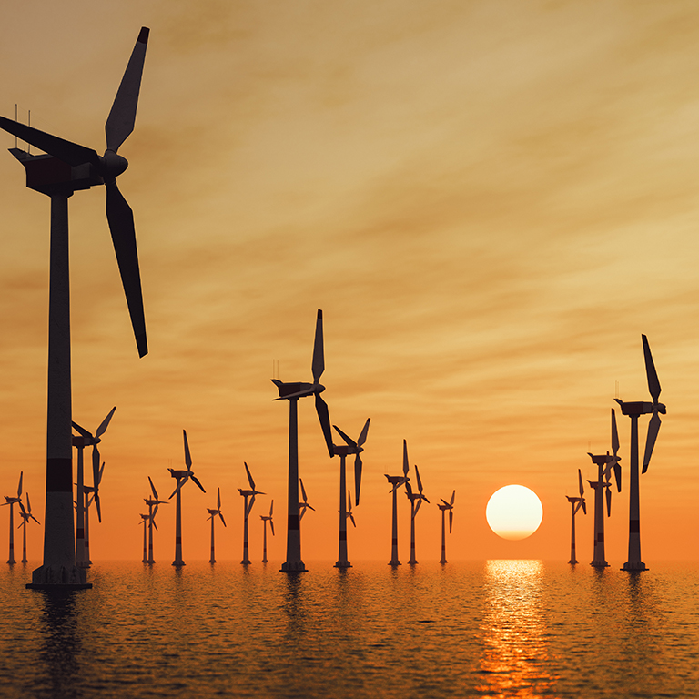 Offshore wind turbine farm at sunset.